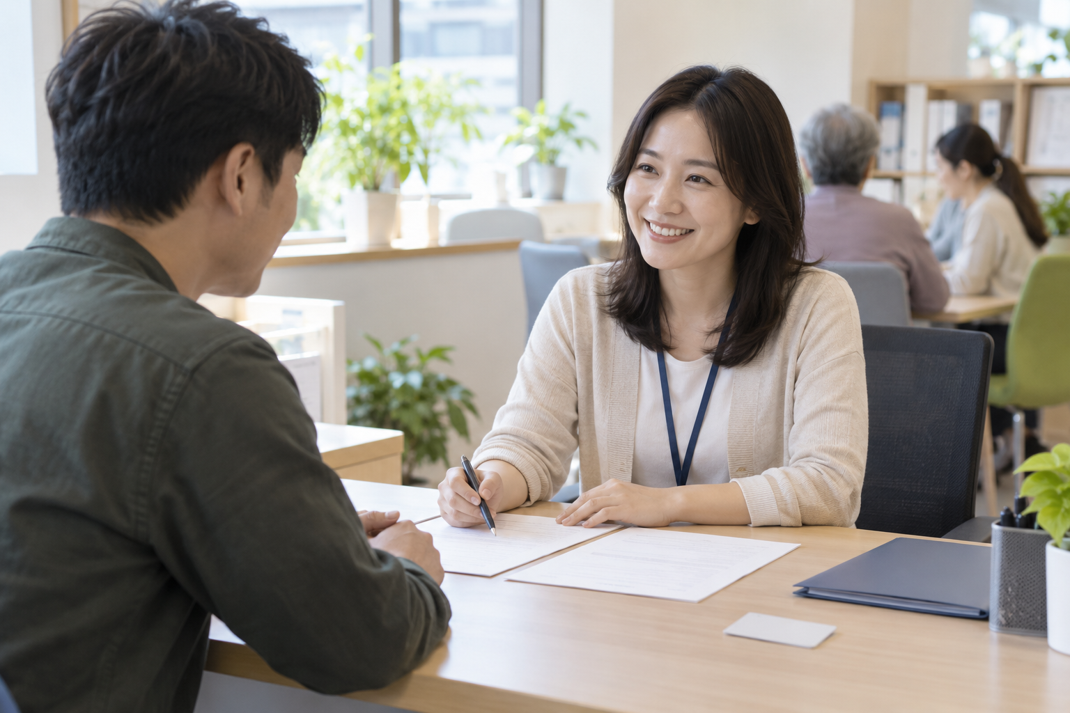 지역적응센터 상담자가 신청자에게 빈 신청서류를 안내하는 연출 사진