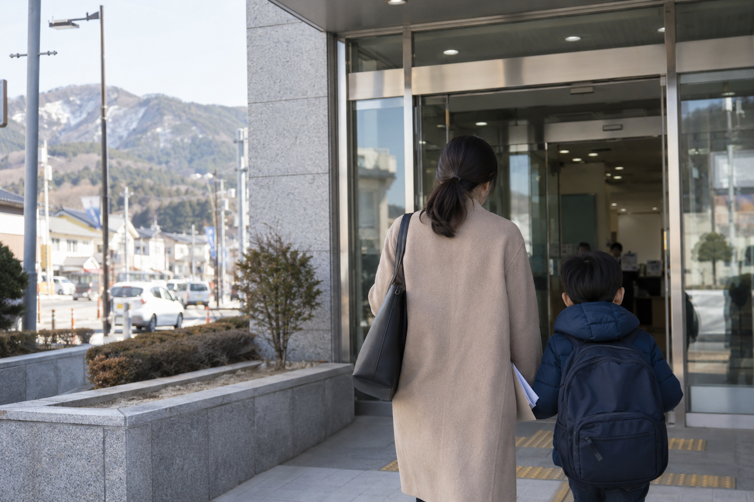 보호자와 초등학생이 작은 도시의 민원 건물로 들어가는 연출 사진
