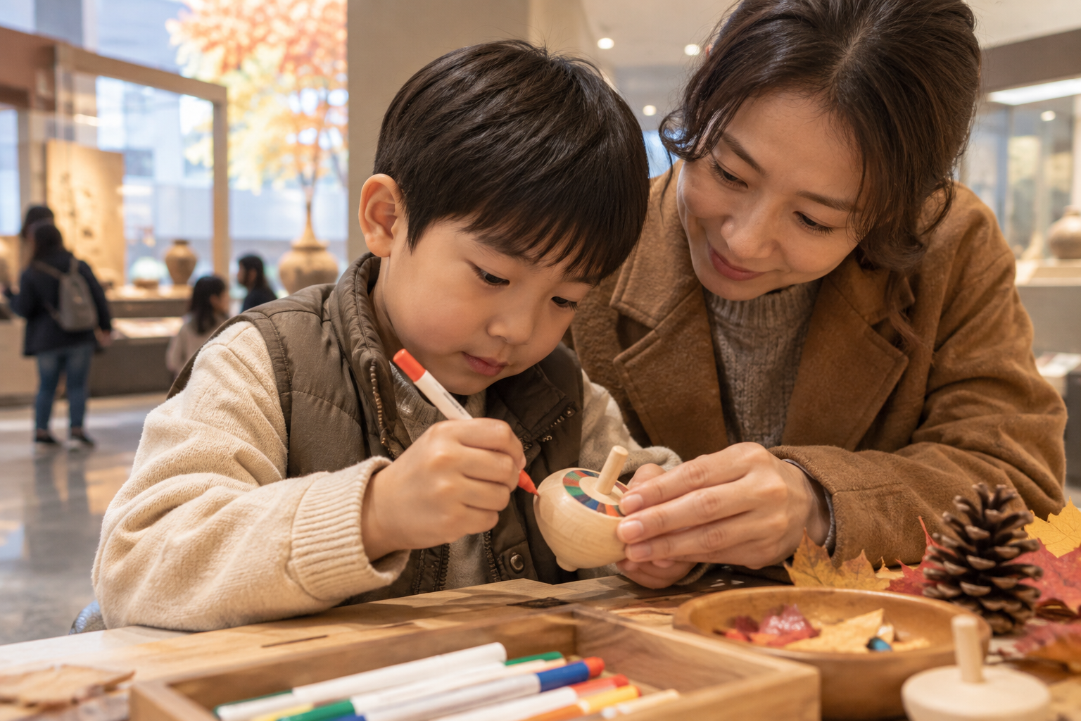 어린이가 보호자와 함께 작은 팽이를 꾸미는 연출 장면